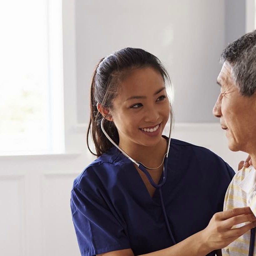 A home care nurse smiling with an older client at home