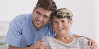 a caregiver and a senior woman smiling