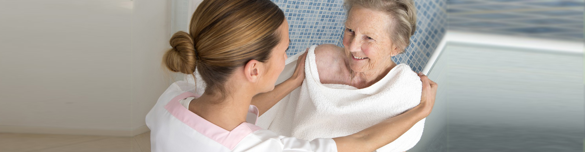 a caregiver helping a senior woman take a shower